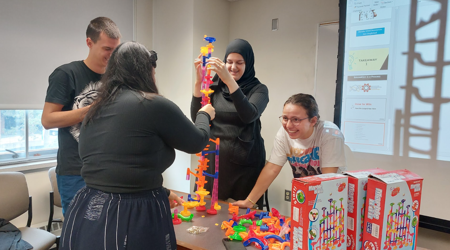 BOLD Fellowship participants engaging in a team-building activity, constructing a toy tower during an entrepreneurship workshop.